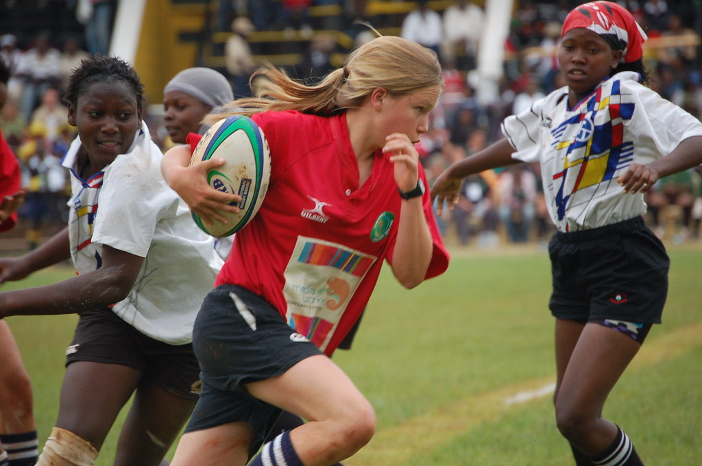 A player breaking through a tackle in a women’s rugby match